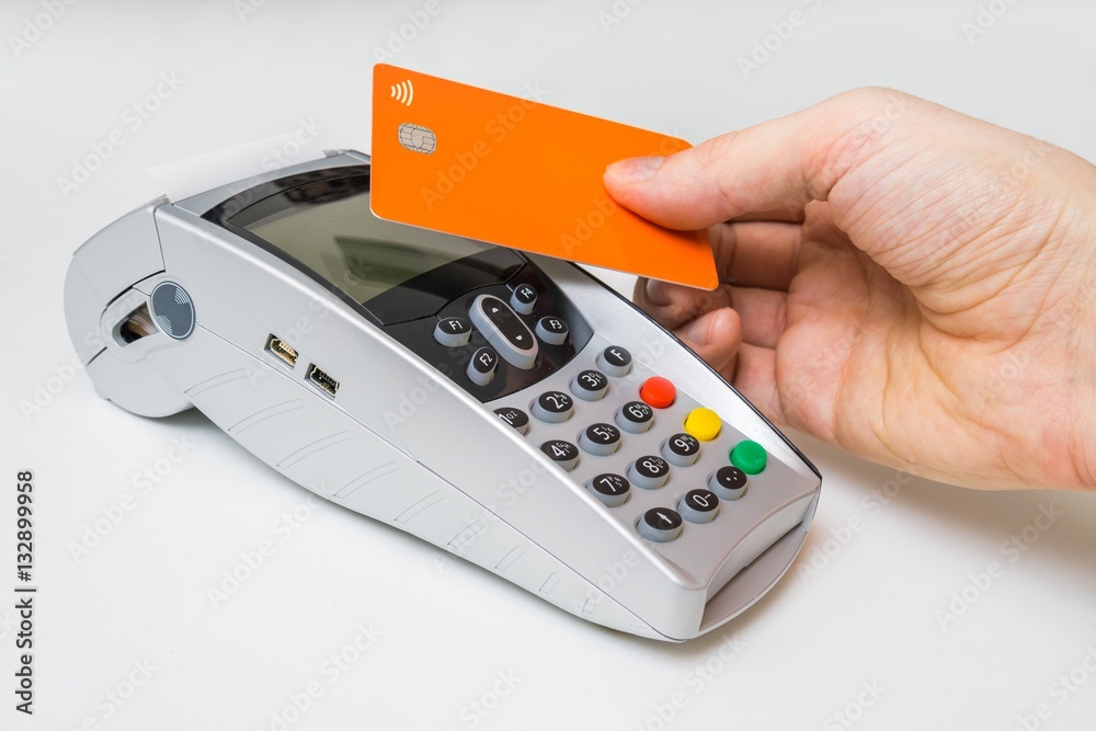 Customer is paying using contactless credit card and payment terminal. Customer is paying using contactless credit card and payment terminal.