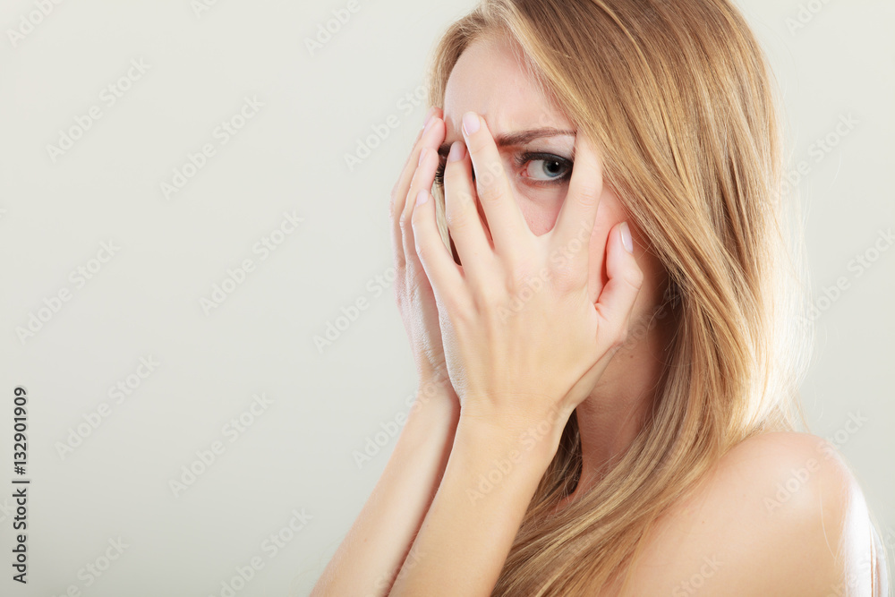 Afraid frightened woman peeking through her fingers Afraid frightened woman peeking through her fingers