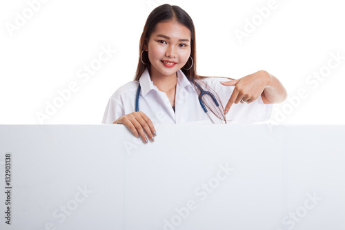 Young Asian female doctor point down to blank sign.