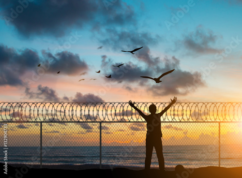 Φωτογραφία silhouette prisoners were imprisoned on the island alone, praying and free bird fly over blurred nature sunset background