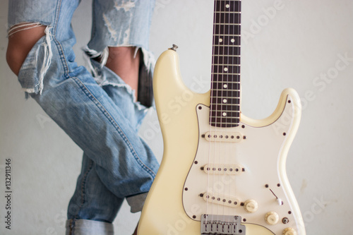 Canvas Print .A young man with an electric guitar Leaning against a cement wa
