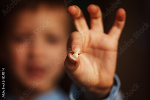 Kids Hand with one milk tooth. First tooth lost.