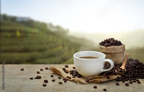 Hot Coffee cup with Coffee beans on the wooden table and the pla