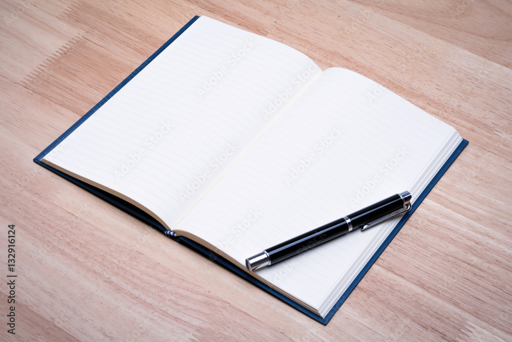 Open blank paper leather notebook with pen on wooden table. Open blank paper leather notebook with pen on wooden table.
