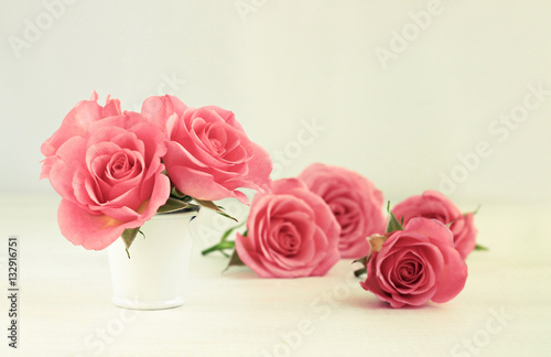 Pink rose flowers in little white tin bucket. Spring decor. Soft focus, Romantic warm creamy tones. 