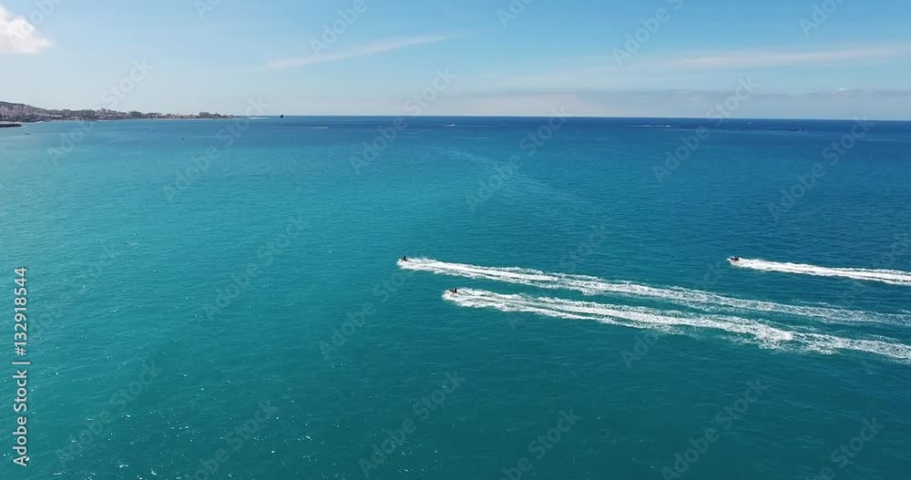 AERIAL: a group of pilots slide over the sea using water scooters. AERIAL: a group of pilots slide over the sea using water scooters.