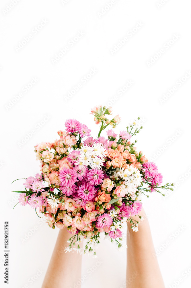 Girl's hands holding wildflowers bouquet on white background. Flat lay, top view Girl's hands holding wildflowers bouquet on white background. Flat lay, top view