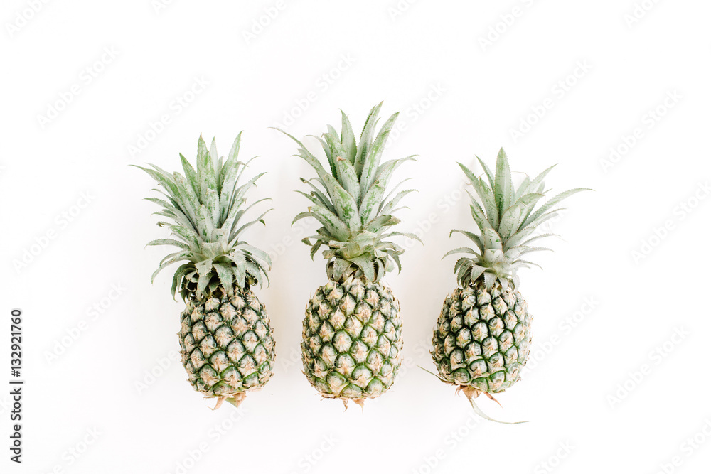 Pineapples on white background. Flat lay, top view. Creative food concept Pineapples on white background. Flat lay, top view. Creative food concept