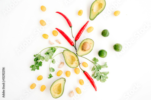 Raw food ingredients of guacamole: avocado, chili pepper, coriander, cherry tomato, lime, garlic. Flat lay, top view. Food concept.