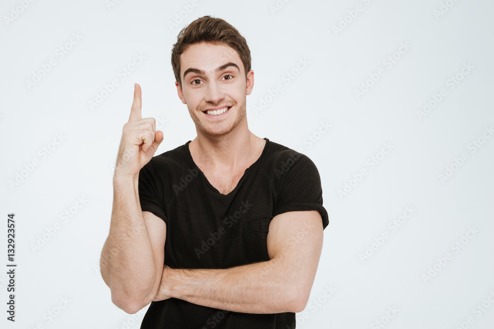 Young cheerful man looking at camera while pointing. Young cheerful man looking at camera while pointing.