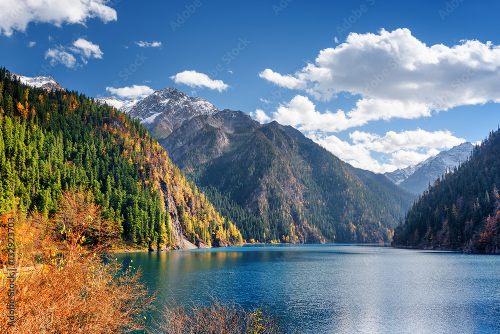 Beautiful view of the Long Lake among fall woods and mountains