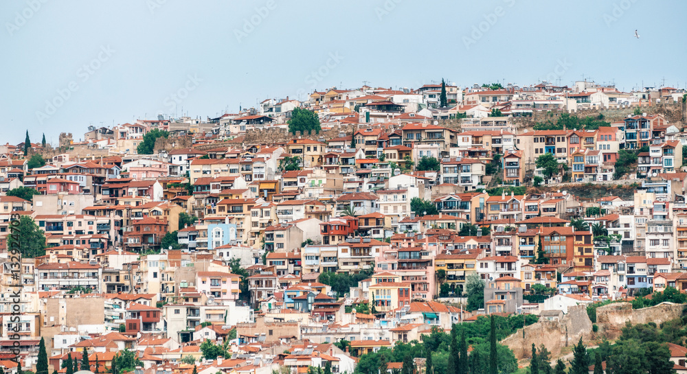 Aerial panoramic view of the colorful Thessaloniki city. Houses with red tile roofs are arranged in row on a hill. Greece