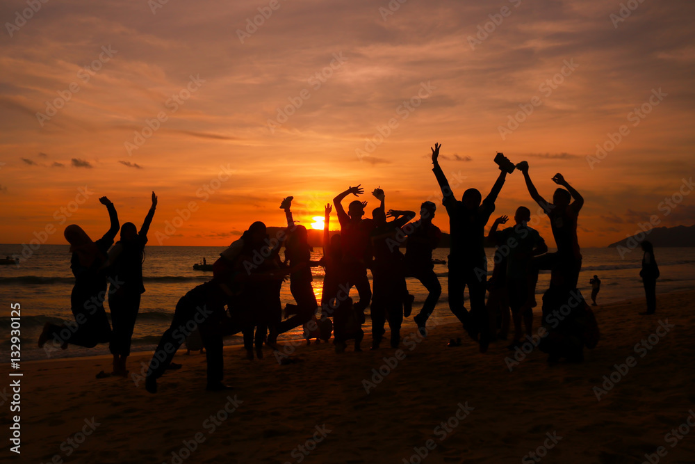 silhouette of happiness peoples jump over the sunset