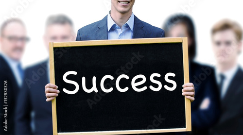 young man in front of group holding sign with word Success
