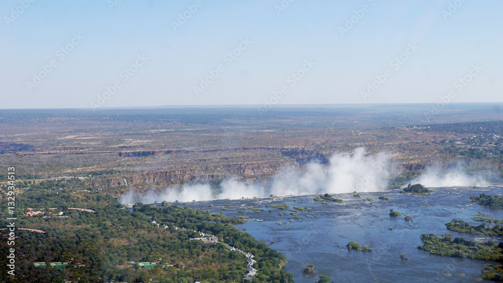 Der Sambesi kurz vor der Abbruchkante/Der Sambesi in Sambia aus der Luft, die Abbruchkante und die Gischt der Victoriafälle und eine Canyon-Landschaft im Hintergrund.