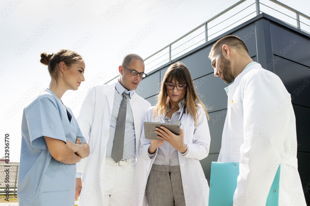 Group of doctors using digital tablet outdoors Group of doctors using digital tablet outdoors