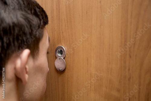 man looks through the peephole
