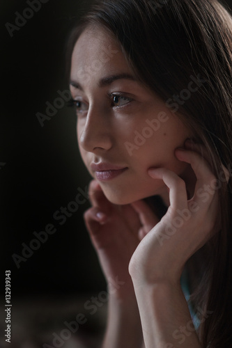Portrait of a beautiful young woman looks out the window