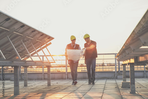 Architect and engineer inspecting solar power station photo