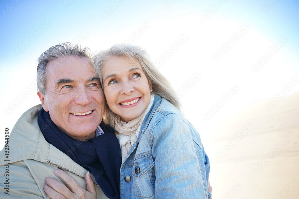 Portrait of senior couple having fun at the beach, wintertime Portrait of senior couple having fun at the beach, wintertime