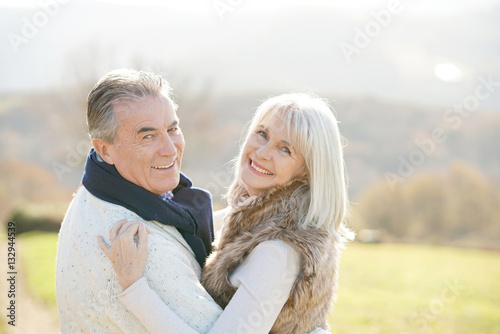 Portrait of cheerful senior couple enjoying day in countryside