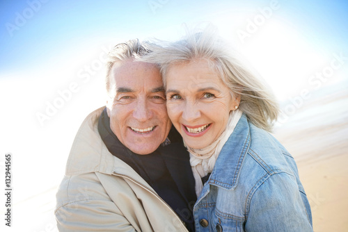 Portrait of senior couple having fun at the beach, wintertime