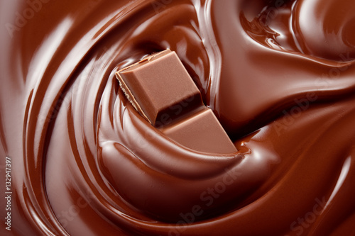 Melted hot liquid chocolate with chocolate pieces. Background.