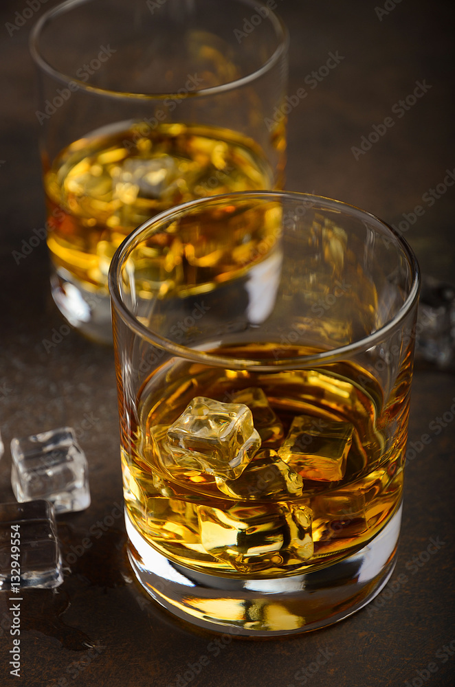 Glass of whiskey with ice on the old rusty background, selective focus, vertical Glass of whiskey with ice on the old rusty background, selective focus, vertical
