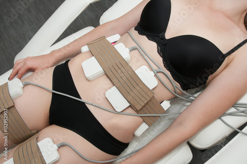 Pretty young woman on laser liposuction in cosmetic cabinet