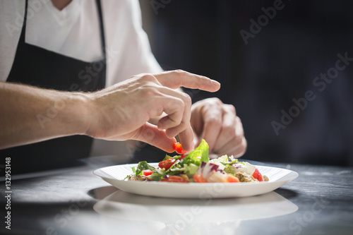 Chef hands preparing vegetable salad