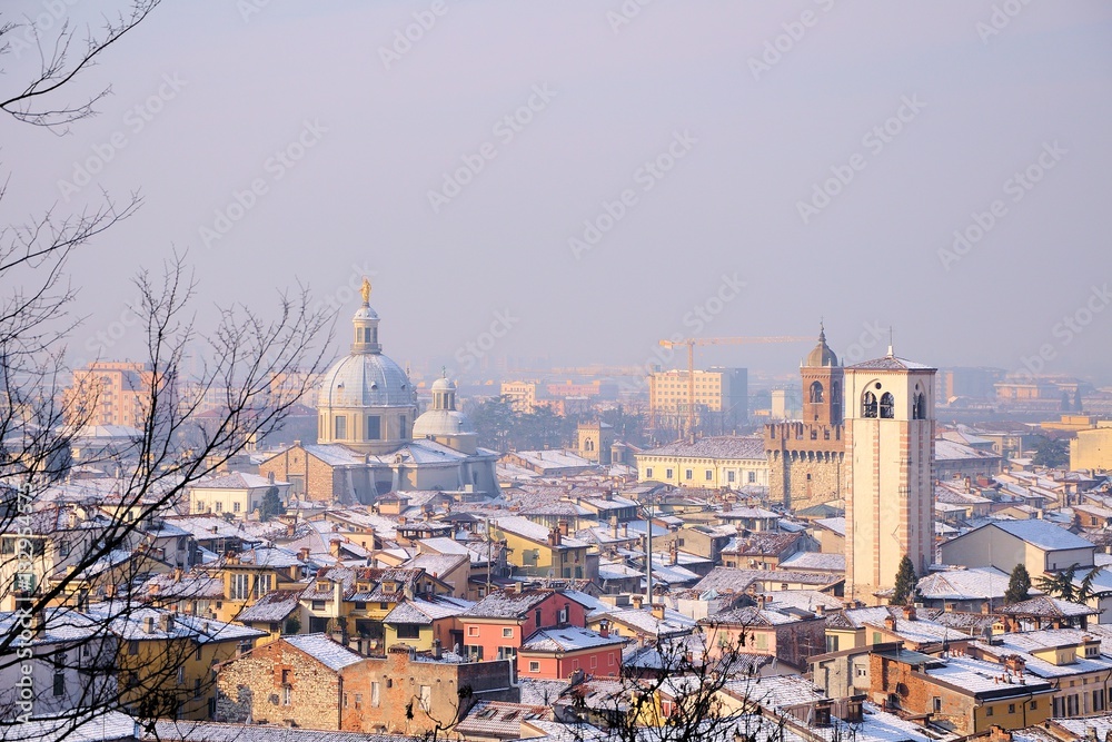 View over the city rooftops with sunlight and snow. Brescia, Italy.