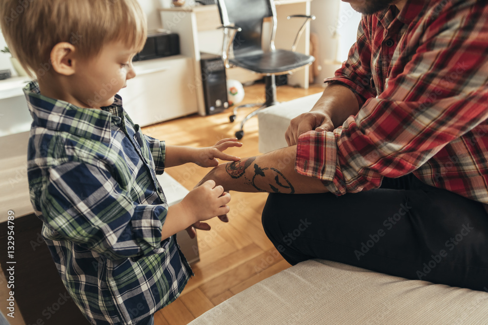 Son looking at father's tattoo Son looking at father's tattoo