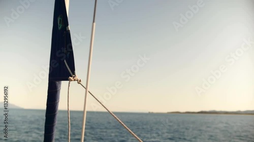 Sailboat setting up sail. Hoisting sail.