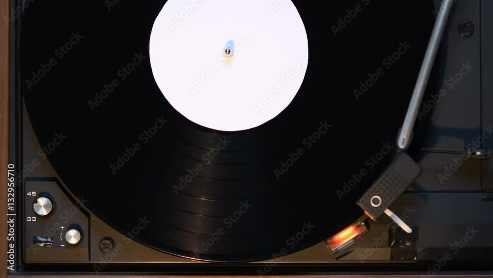 Record player playing an old fashioned vintage vinal record. The needle is being put on the record.