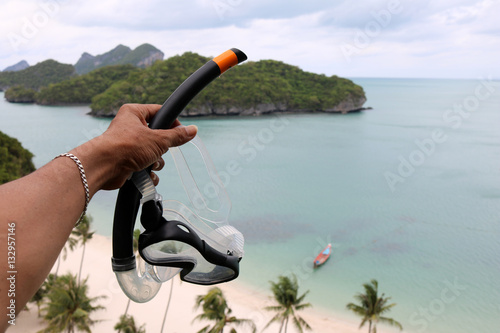 Hand holding the diving mask on the view point of ang thong archipelago island. Thailand. 