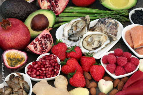 Quadro su tela Aphrodisiac health food in heart shaped dishes and loose over marble background