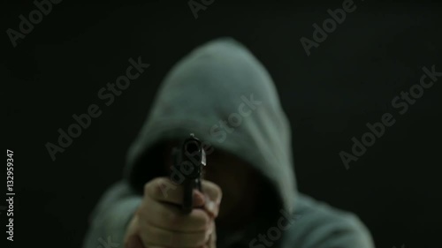 Man in green hoodie points gun and fires