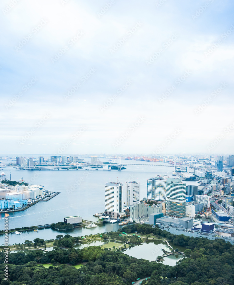 Business and culture concept - panoramic modern city skyline bird eye aerial view of Odaiba bay and rainbow bridge under dramatic morning blue cloudy sky in Tokyo, Japan..
