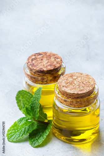 Organic essential mint oil with green leaves photo