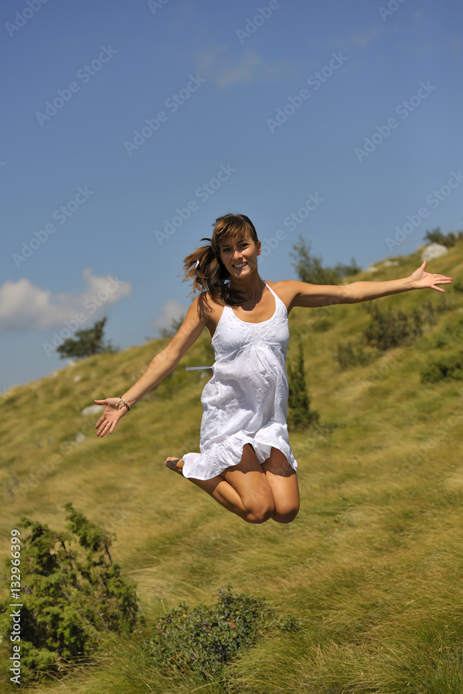 Beautiful woman jumping in nature. She is happy and smiling. Beautiful woman jumping in nature. She is happy and smiling.