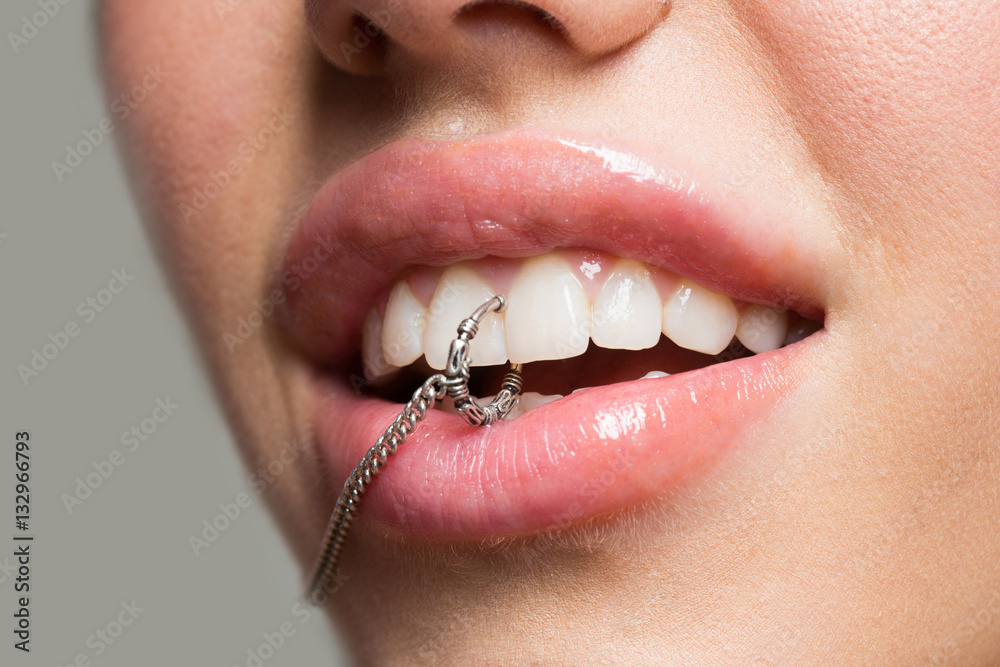 Piercings close up in the mouth of a young girl with full lips, white teeth  with natural make-up. Sexy piercing in teeth – Stock-Foto | Adobe Stock