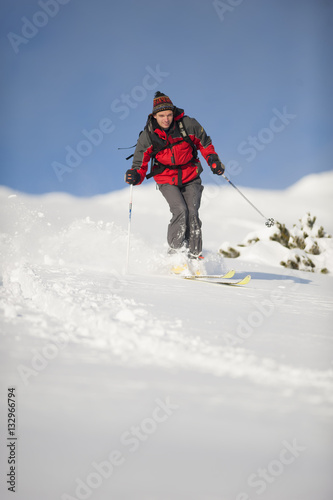 Man is skiing in deep snow out of ski run in pure nature