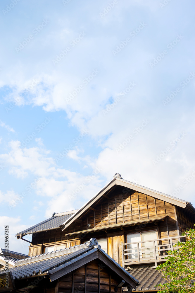 culture concept - japanese traditional historical wooden old house under golden sun and morning blue cloudy sky culture concept - japanese traditional historical wooden old house under golden sun and morning blue cloudy sky