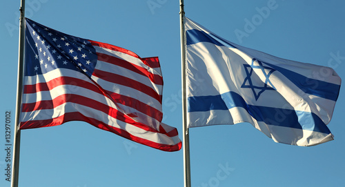 Foto American and Israeli flags waving in the blue sky
