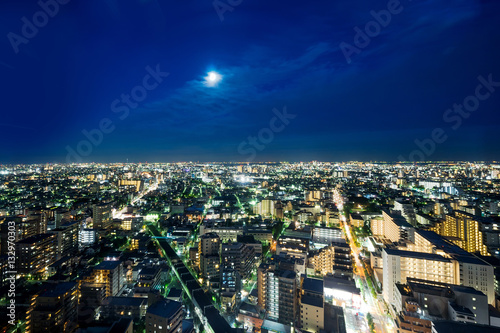 Business and culture concept for real estate and corporate construction - panoramic modern city skyline bird eye aerial night view under dramatic neon glow and beautiful dark blue sky in Tokyo  Japan