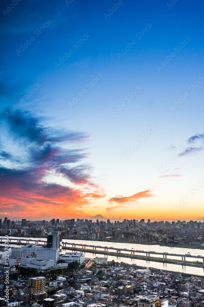 Business and culture concept - panoramic modern city skyline bird eye aerial view with Mountain Fuji under dramatic sunset glow and beautiful cloudy sky in Tokyo, Japan
