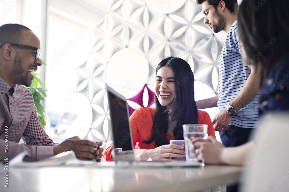 Young caucasian businesswoman laughing during a meeting with multi ethnic colleagues Young caucasian businesswoman laughing during a meeting with multi ethnic colleagues