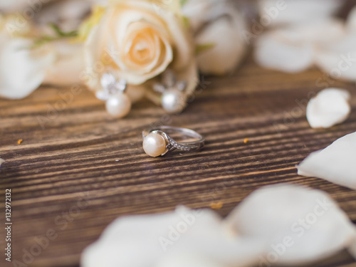 Pearl ring on beautiful wooden background with rose. close up