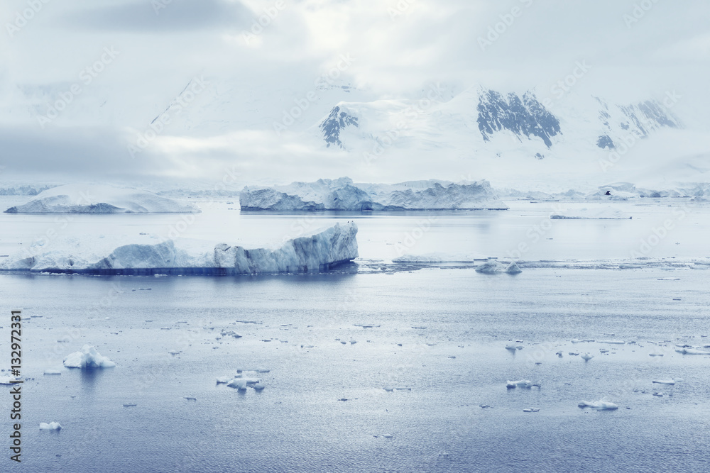 Low clouds over the mountains and chunks of ice floating of Port Lockroy research station, Antarctica, Polar Low clouds over the mountains and chunks of ice floating of Port Lockroy research station, Antarctica, Polar
