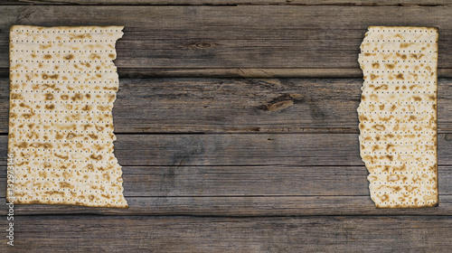 Two pieces of matzah or matza on a vintage wood background with photo